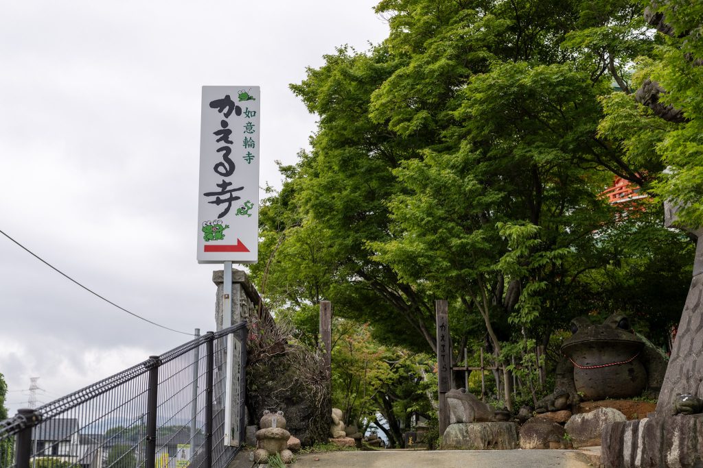 福岡県小郡市の如意輪寺かえる寺の入口看板と緑に囲まれた参道