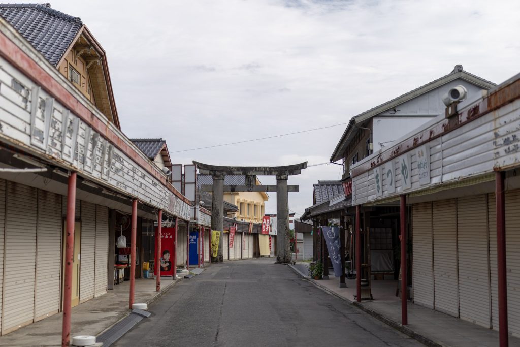 祐徳稲荷神社へ向かう門前商店街の通りと鳥居が見える朝の風景