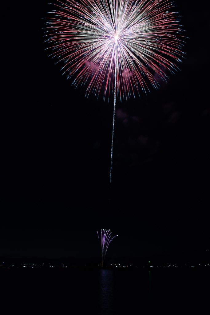 天草ほんど花火大会で、海辺の夜空に大きく開いた色鮮やかな打ち上げ花火