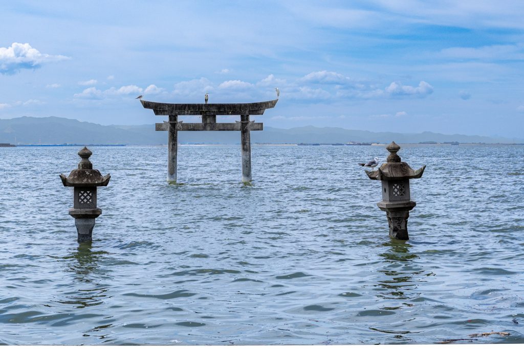 永尾剱神社の海中鳥居と2基の石灯籠、鳥居や灯籠にとまる野鳥を撮影した写真