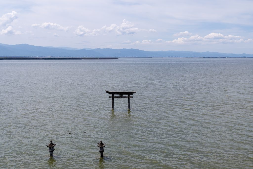 永尾剱神社の境内側から、不知火海に立つ海中鳥居と石灯籠を見下ろした写真